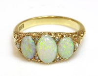 Lot 315 - A three stone opal and diamond carved head ring