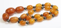 Lot 1020 - A single row of graduated oval amber beads