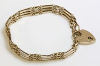 Lot 1049 - An Edwardian gold three row gate bracelet