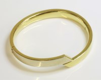 Lot 1026 - An 18ct gold two colour hinged bangle