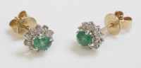 Lot 1019 - A pair of emerald and diamond oval cluster earrings