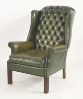 Lot 1608 - A green leather wing armchair