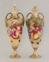 Lot 1089 - A pair of Royal Worcester twin handled urns and covers
