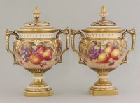 Lot 1095 - A pair of Royal Worcester urns and covers