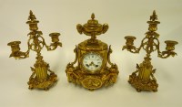 Lot 1301 - A gilt metal clock garniture