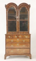 Lot 548 - A walnut double dome top cabinet on chest