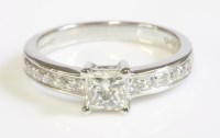 Lot 64 - An 18ct white gold single stone diamond ring with diamond set shoulders
