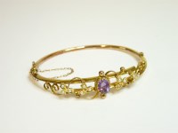 Lot 31 - An Edwardian 9ct gold amethyst and split pearl bangle