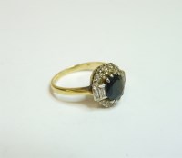 Lot 70 - An 18ct gold oval sapphire and diamond cluster ring