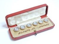 Lot 100 - A cased set of six gold mother of pearl and enamel buttons