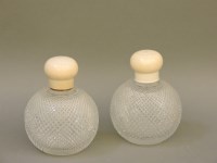 Lot 256 - A pair of ivory top hobnail cut glass scent bottles