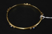 Lot 9 - A blue glass and cubic zirconia set gold bangle