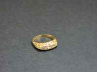 Lot 28 - An 18ct gold five stone diamond carved head ring