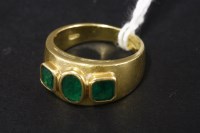Lot 44 - A three stone emerald tapered gold band ring
