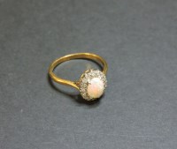 Lot 42 - An opal and diamond oval cluster ring
