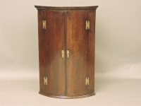 Lot 606 - A George III mahogany bow front hanging corner cupboard