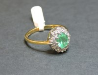 Lot 11 - An 18ct gold emerald and diamond oval cluster ring