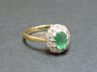 Lot 9 - A 9ct gold emerald and diamond oval cluster ring