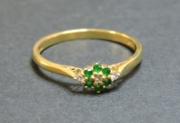 Lot 59 - An 18ct gold diamond and emerald cluster ring