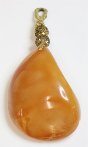 Lot 337 - A free-form butterscotch amber pendant