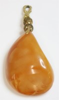 Lot 337 - A free-form butterscotch amber pendant