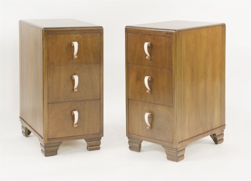 Lot 207 - A pair of walnut three-drawer bedside chests