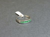 Lot 10 - An 18ct white gold emerald half eternity ring