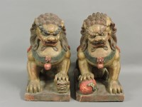 Lot 640 - A pair of Chinese carved wood Buddhist lions