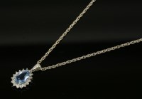 Lot 592 - An 18ct white gold aquamarine and diamond cluster pendant