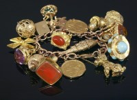 Lot 546 - A curb link gold charm bracelet with assorted charms