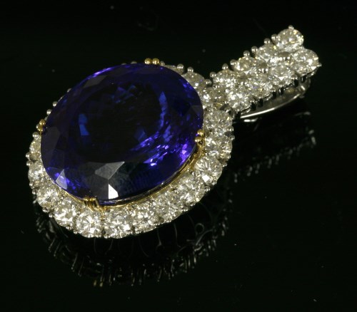 Lot 618 - A two colour gold tanzanite and diamond oval cluster pendant