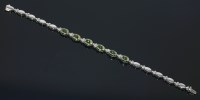 Lot 597 - A 9ct white gold peridot and diamond bracelet