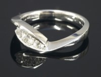 Lot 644 - An 18ct gold three stone diamond crossover ring