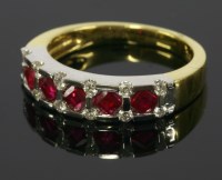 Lot 679 - An 18ct yellow and white gold ruby and diamond half eternity ring