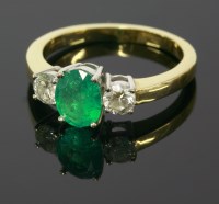 Lot 685 - An 18ct yellow and white gold emerald and diamond three stone ring