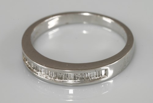 Lot 1009 - A 9ct white gold baguette cut diamond channel set half eternity ring