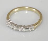 Lot 1016 - An 18ct yellow and white gold baguette cut diamond and brilliant cut diamond half eternity ring