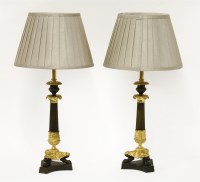Lot 67 - A pair of bronze and parcel-gilt candlestick table lamps