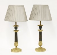Lot 68 - A pair of Victorian bronze parcel-gilt candlestick table lamps