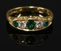 Lot 680 - An 18ct gold emerald and diamond five stone boat shaped ring