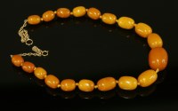 Lot 378 - A single row graduated olive shaped amber bead necklace