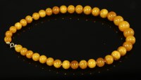 Lot 380 - A single row graduated circular amber bead necklace