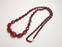 Lot 14 - A row of faceted oval red bakelite beads