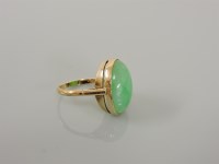 Lot 33 - A gold single stone jade ring