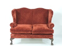 Lot 563 - A red upholstered wing back settee