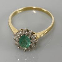 Lot 8 - An 19ct gold emerald and diamond oval cluster ring