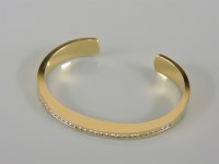 Lot 14 - An 18ct gold diamond set torque bangle