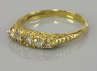 Lot 1 - An 18ct gold five stone diamond set carved head ring