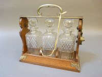 Lot 126 - An Edwardian oak and silver plated mounted three bottle tantalus