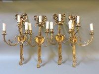 Lot 277 - A set of four gilt metal three branch wall lights